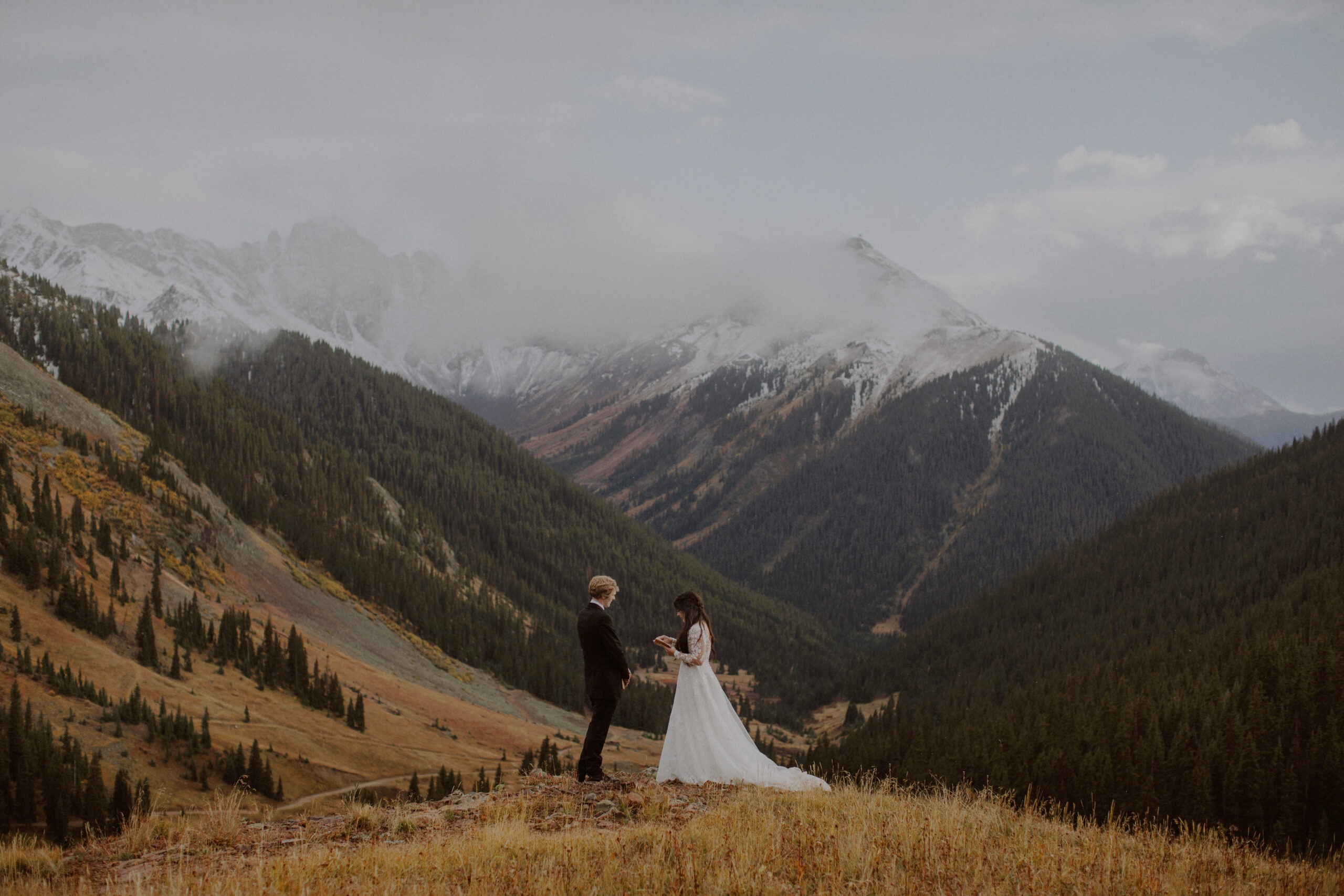 Couple reads their vows with snowy mountain peaks behind them