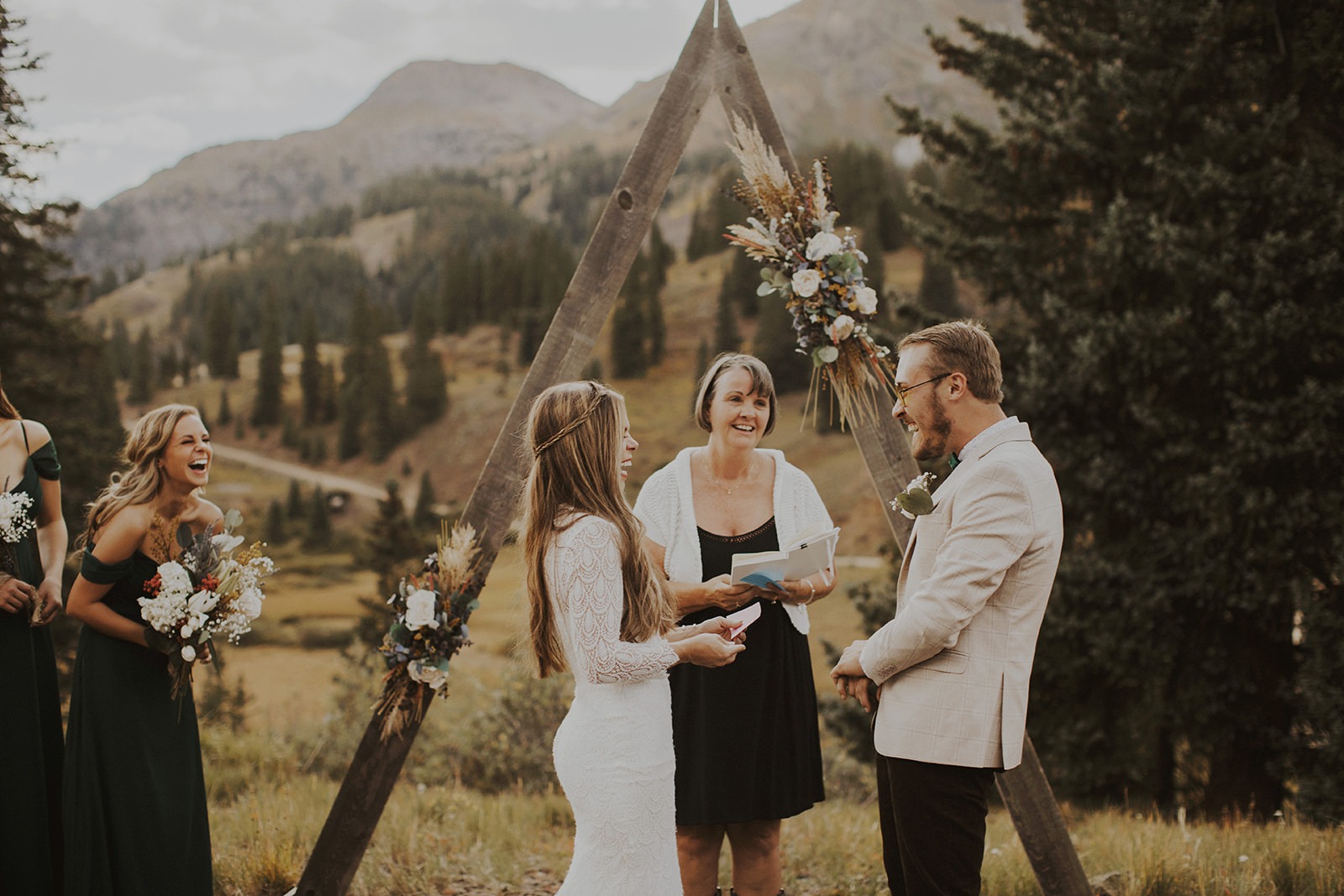 Bride and groom laugh as they read their vows to each other.